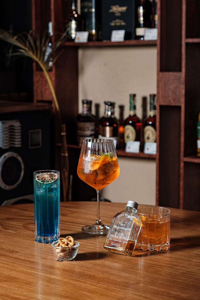 An elegant assortment of cocktails displayed on a rustic bar table in a cozy setting.
